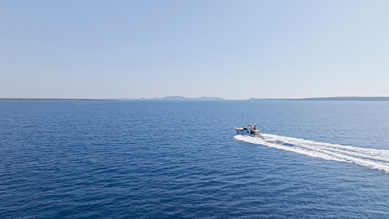 Aerial view of luxury yacht moving fast at Adriatic sea during sunny day.