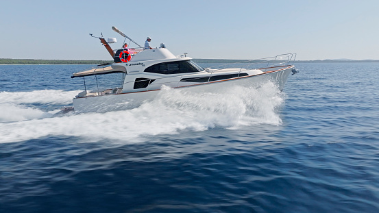 Runswick Bay, England - August 27, 2015: A Finnmaster 4900clx speedboat anchored close to the beach at Brunswick Bay.