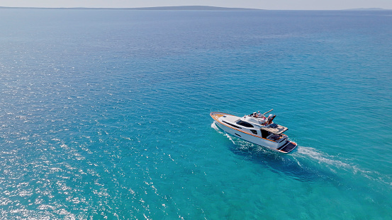 Aerial view of luxury yacht moving fast at Adriatic sea during sunny day.