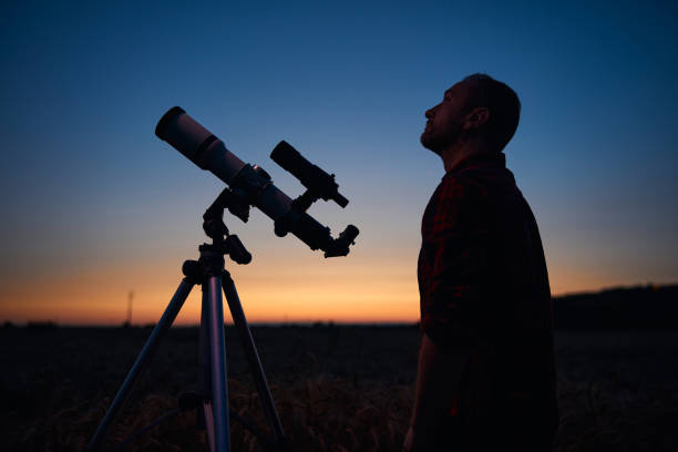 istock Astronomer looking at night sky with a telescope. 1874160097