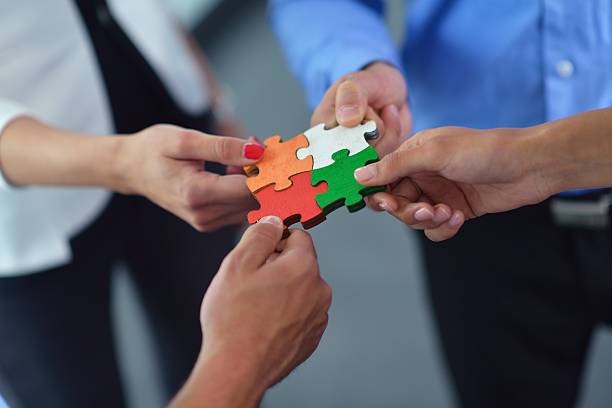 istock Group of business people assembling jigsaw puzzle 187417325