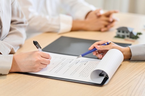 A woman signing a real estate contract