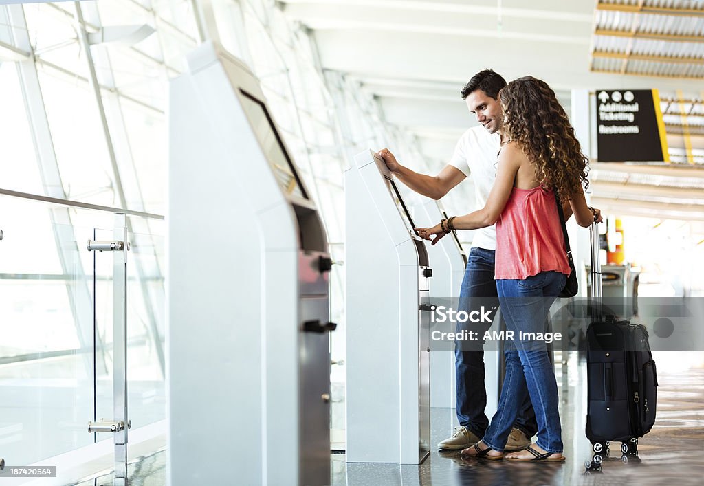 Heterosexuelles Paar mit schnellen Check-In im Flughafen - Lizenzfrei Kiosk Stock-Foto