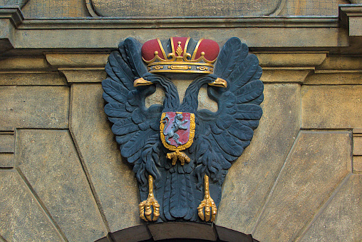 Prague, Czech Republic - October 6, 2023: Coat of arms of the city of Prague on an ancient stone wall. Decoration in the form of a two-headed eagle.