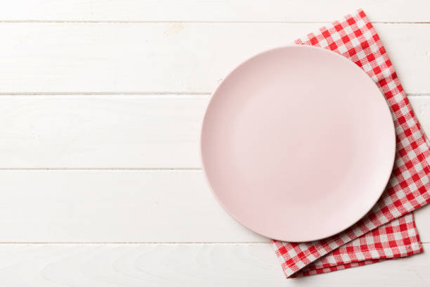 istock Top view on colored background empty round pink plate on tablecloth for food. Empty dish on napkin with space for your design 1874221121