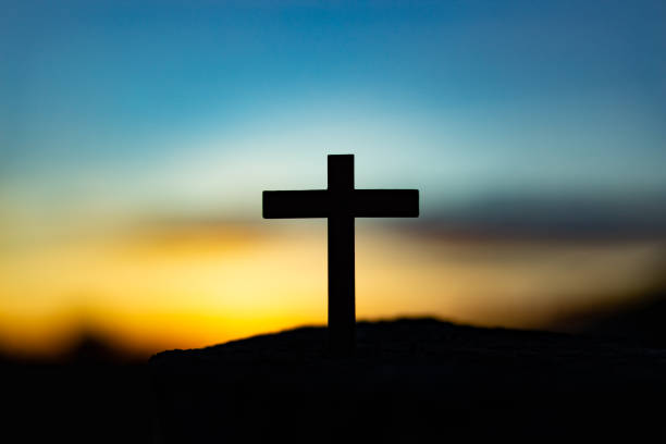 istock Silhouetted cross atop a hill at sunset. Religious iconography. 1874239008
