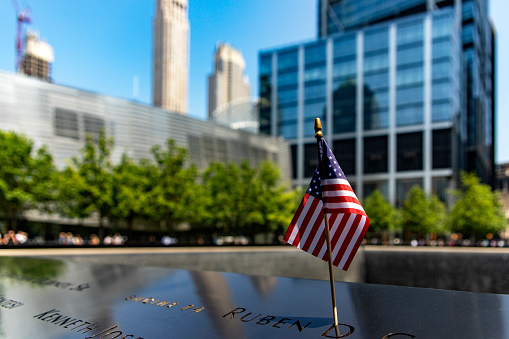 New York, USA; June 1, 2023: U.S. flag at the World Trade Center memorial, honoring the victims of the terrorist attack of 11s.