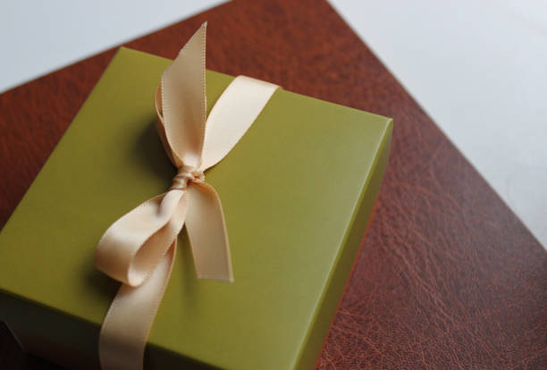 istock Gift box in a simple business style on a leather folder for papers 1874257935
