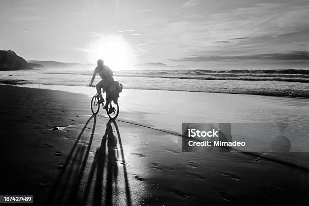 Biker Biking On Beach At Sunset With Bicycle Shadow Stock Photo - Download Image Now