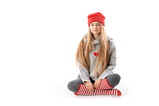 Blond girl in a red hat sitting in front of the camera