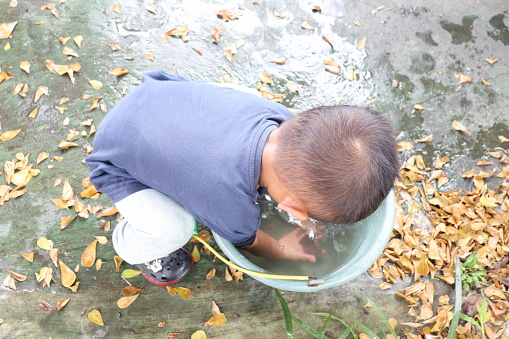 Child playing water in the bucket