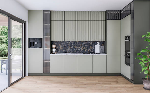 Modern khaki green kitchen with a space (for an island or a table) on the hardwood floors and a large open window door with a garden view on the side stock photo