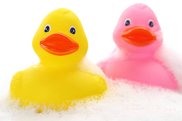 istock Yellow and pink rubber ducks in bath foam 187429714