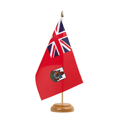 A beautiful miniature Bermuda desk flag isolated on a white background. The little pennant is elegantly attached to a small wooden flag stand.