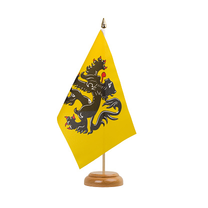 A beautiful miniature Belgium Flanders desk flag isolated on a white background. The little pennant is elegantly attached to a small wooden flag stand.