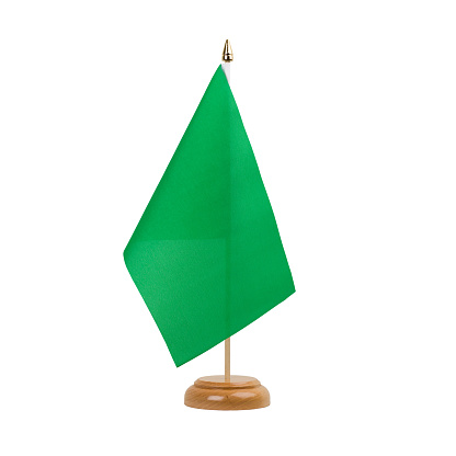 A beautiful miniature green desk flag isolated on a white background. The little pennant is elegantly attached to a small wooden flag stand.