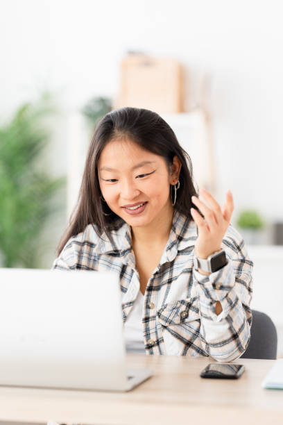 istock Chinese woman working making a video call at home 1874325661