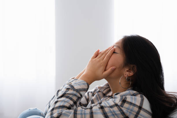 istock Tired and sad woman covering her face with hands 1874327800