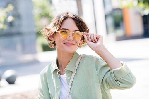 Photo of cheerful good mood girl walking alone city center warm spring days harmony peace cityscape outdoors.