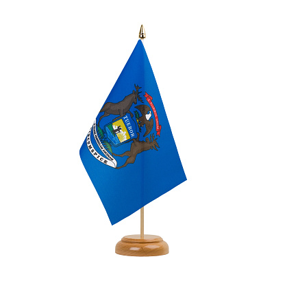 A beautiful miniature Michigan desk flag isolated on a white background. The little pennant is elegantly attached to a small wooden flag stand.