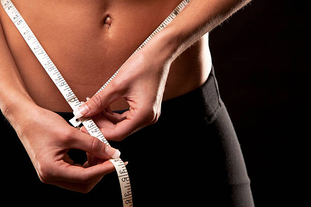istock woman measuring her waist 187438839