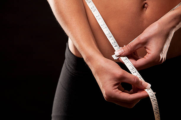 istock woman measuring her waist 187438873