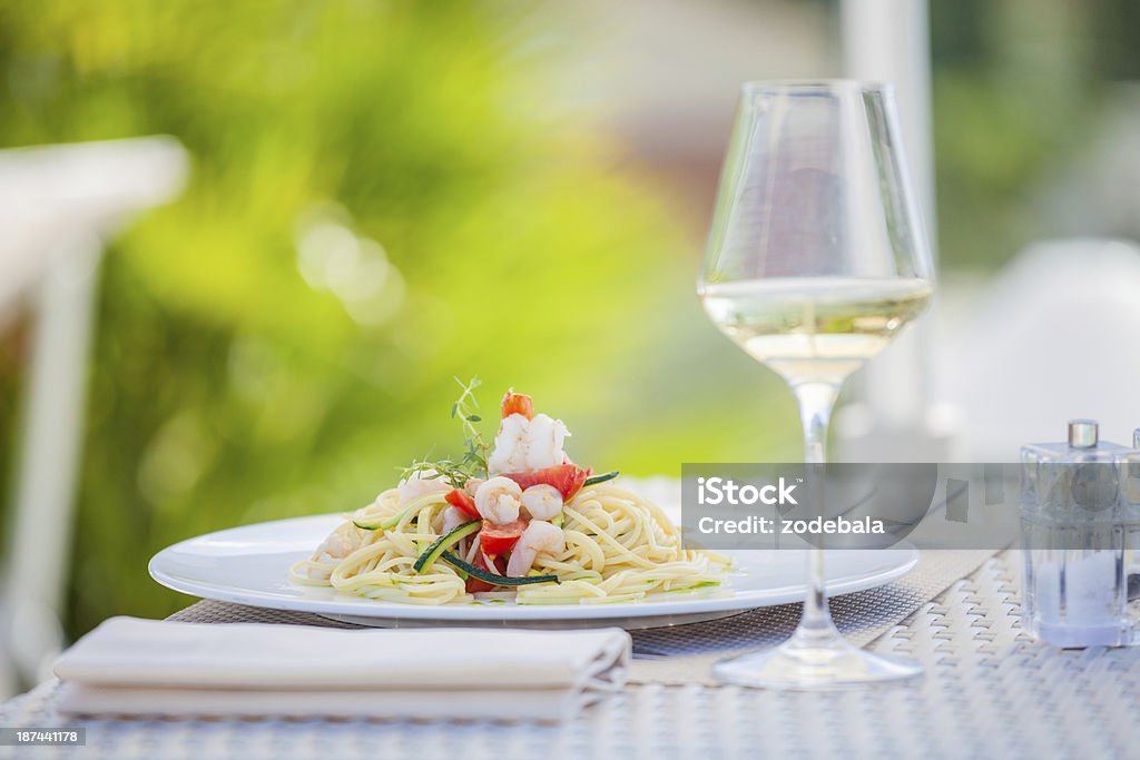 Pasta con pescados, mariscos y vino blanco en el restaurante en el verano - Foto de stock de Elegancia libre de derechos