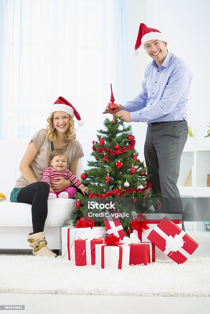 Семья с младенца украшая Рождество дерево. - Стоковые фото Ёлочные игрушки роялти-фри