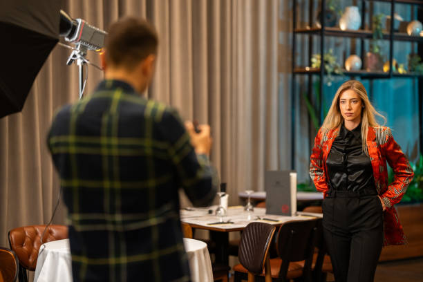 Elegant young woman posing for professional photographer in luxury restaurant