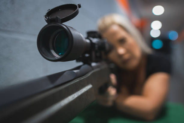 istock A woman sniper shoots from a rifle with optical sight at a shooting range. Soft focus photography. 1874433318