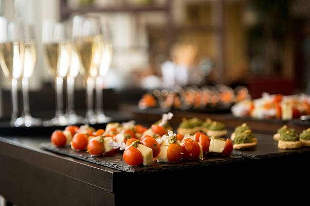 Reception drinks and canapes Tomato and cheese canapés on a dark table backdrop canape stock pictures, royalty-free photos & images
