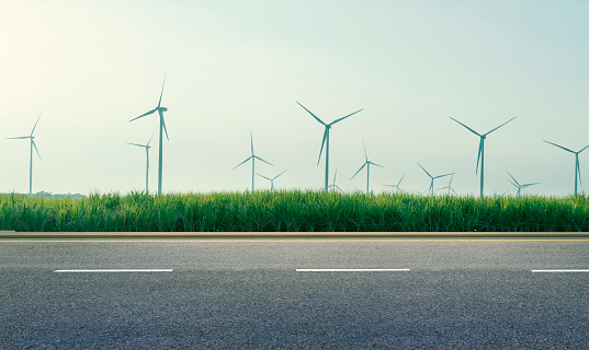 long roads and wind turbine farms behind. clean and renewable energy. Environmentally responsible logistics industry and transportation with the concept of net zero emissions recycling and reuse.