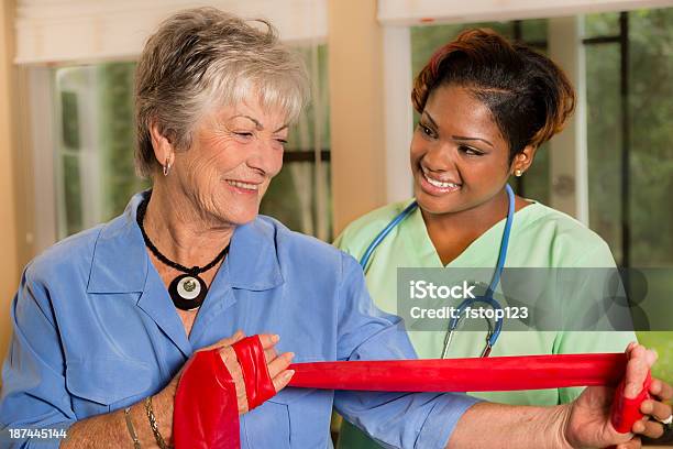 Medical Home Healthcare Nurse Helps Woman With Band Therapy Stock Photo - Download Image Now