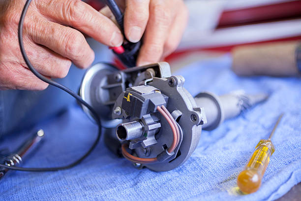 istock Service Industry:  Mechanic tests an ignition distributor in repair shop. 187445468