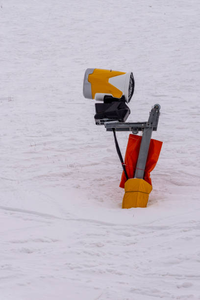 人工雪を作るためのオレンジ色の機械。人工人工降雪システム。冬の山の雪鉄砲。 人工雪を作るための高出力の雪砲です。 - mountain winter season machine snow making machine ストックフォトと画像