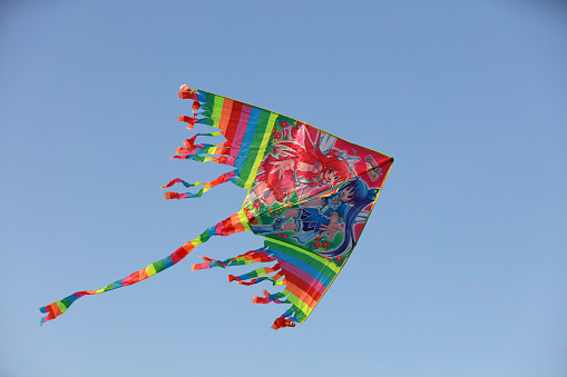 A beautiful butterfly kite flying in the air on a cloudy day.