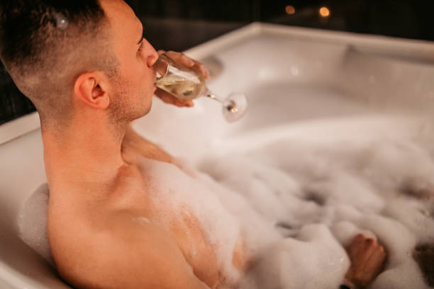 istock Young Man Drinking Champagne In A hot tub 1874482314
