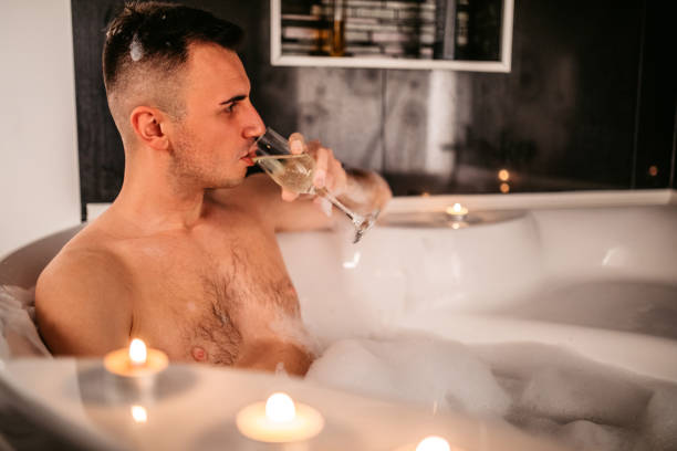 istock Young Man Drinking Champagne In A hot tub 1874504193