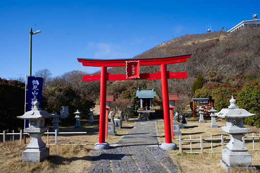Oita, Japan - December 10, 2022: Japanese red torii gate Buddhism inside beautiful Nature on the Top of Mount Tsurumi in beppu