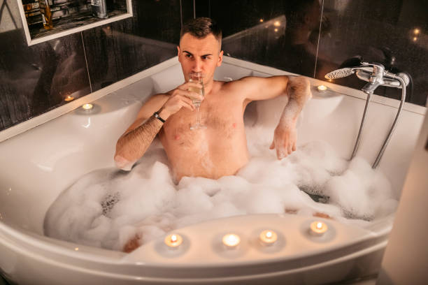 istock Young Man Drinking Champagne In A hot tub 1874507334