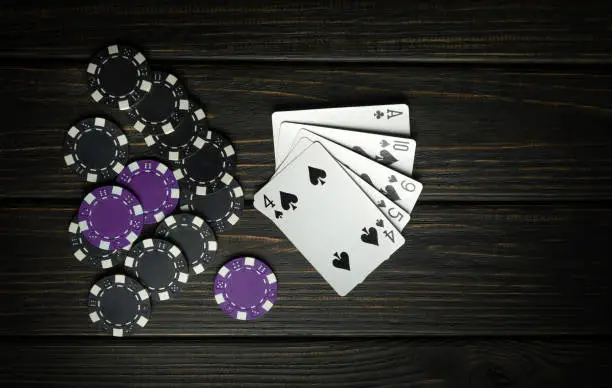 Photo of A popular poker game with a winning combination of high card. Cards with chips on a black vintage table in a poker club