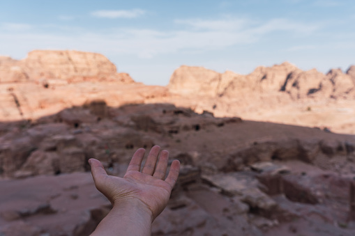 POV of anonymous person's hand showing the beauty of the hidden city of Petra, Jordan. Shot of an unrecognizable young man showing the grandeur of Jordanian desert terrain.