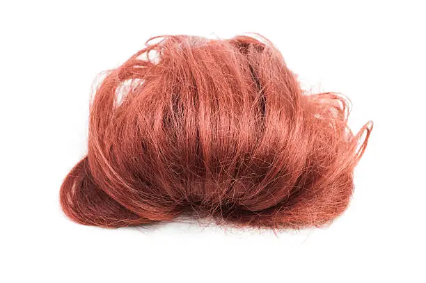 Red synthetic hair wig in quiff style isolated on white.