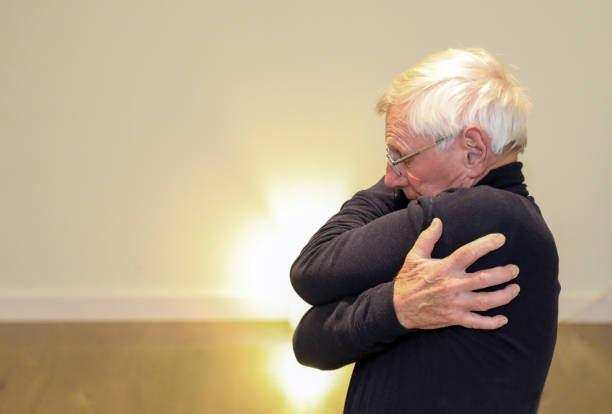 istock Older man stretches shoulders and gives himself a hug 1874571346