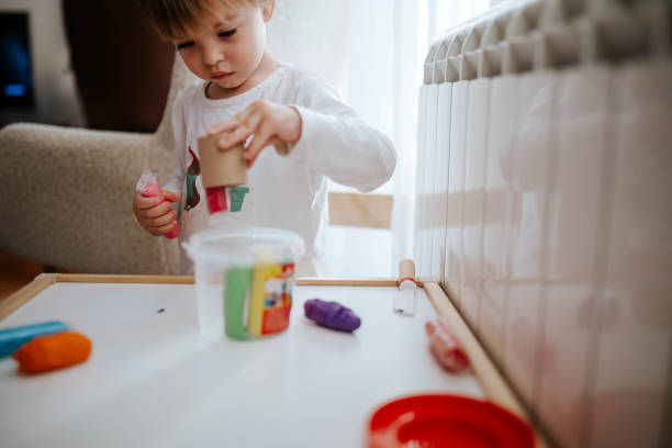 istock Little boy is making shapes of plasticine 1874581812