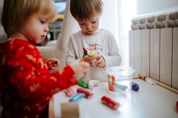 Brother and sister making shapes of plasticine modeling clay
