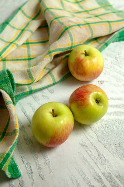 istock Three green apples on white wooden background. 1874588183