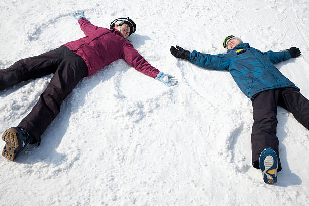 istock Man and Woman Making Snow Angels 187459312