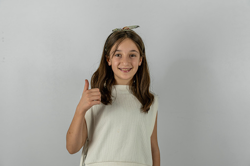 Girl smiling with white background. It's the girl making the okay sign.