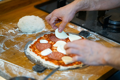 Pizza maker prepares pizza in the kitchen